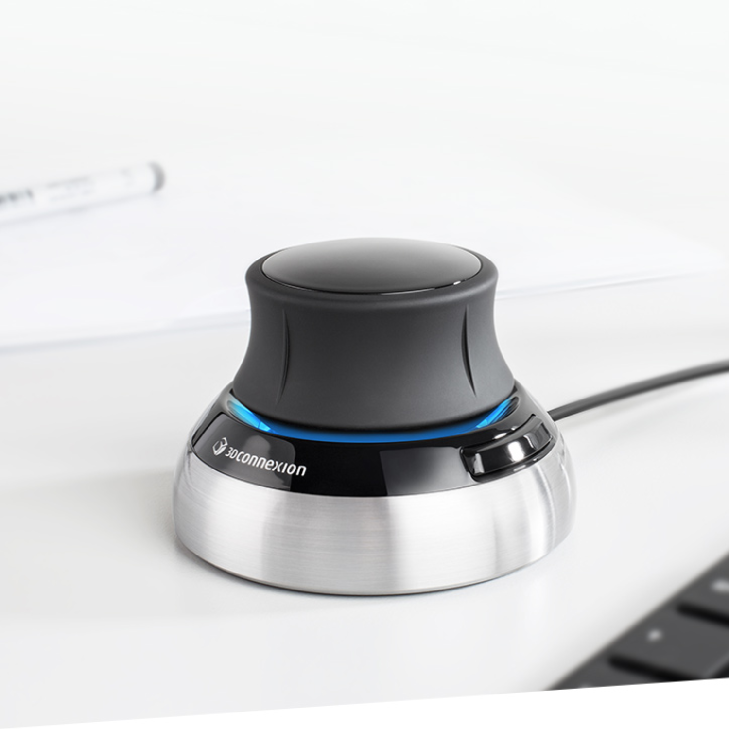 Close-up of the 3Dconnexion SpaceMouse® Compact on a desk, featuring its ergonomic design and brushed metal base.